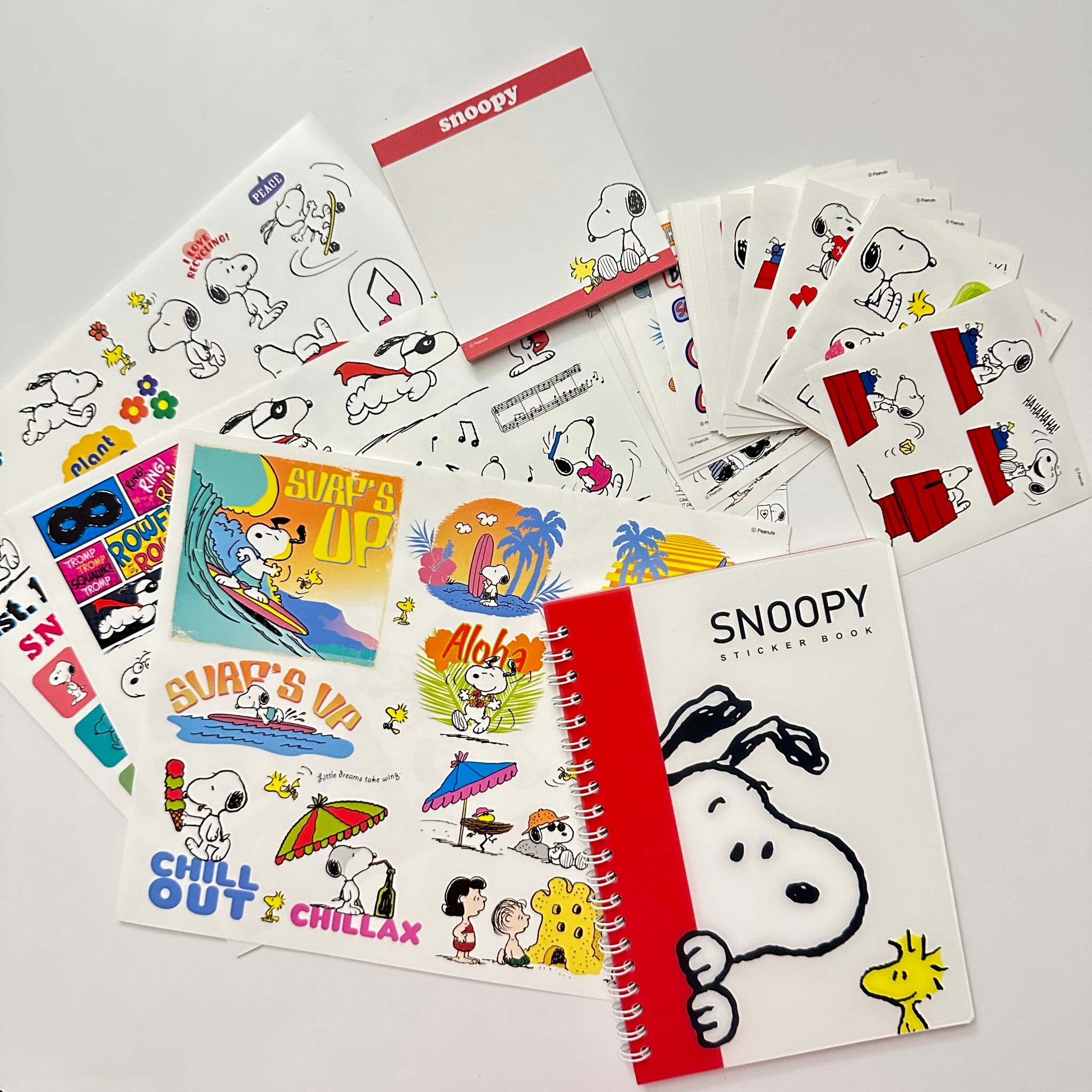 Snoopy-themed sticker books and sheets on a gray background. Official Disney Stationery Canada Snoopy Sticker Book Memo Pad